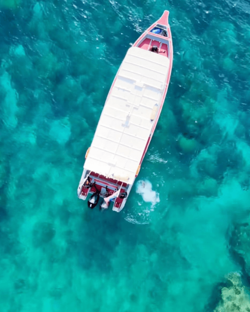 Boat crossing turquoise island waters in Malaysia