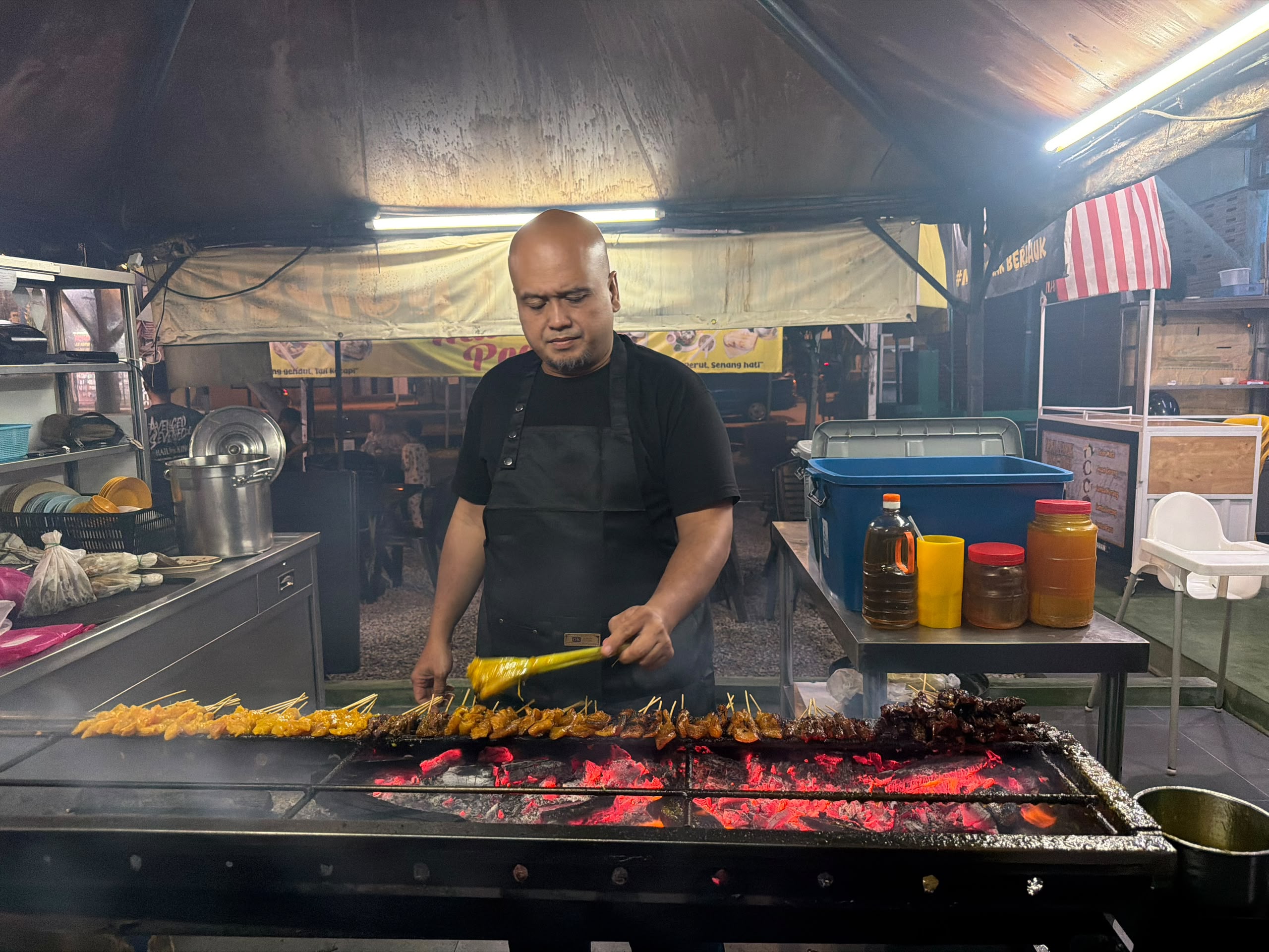 Malaysian street food vendor grilling satay